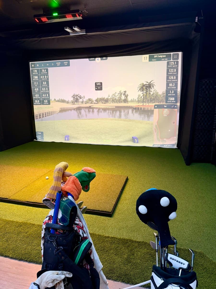Golf simulator bay with premium clubs and equipment