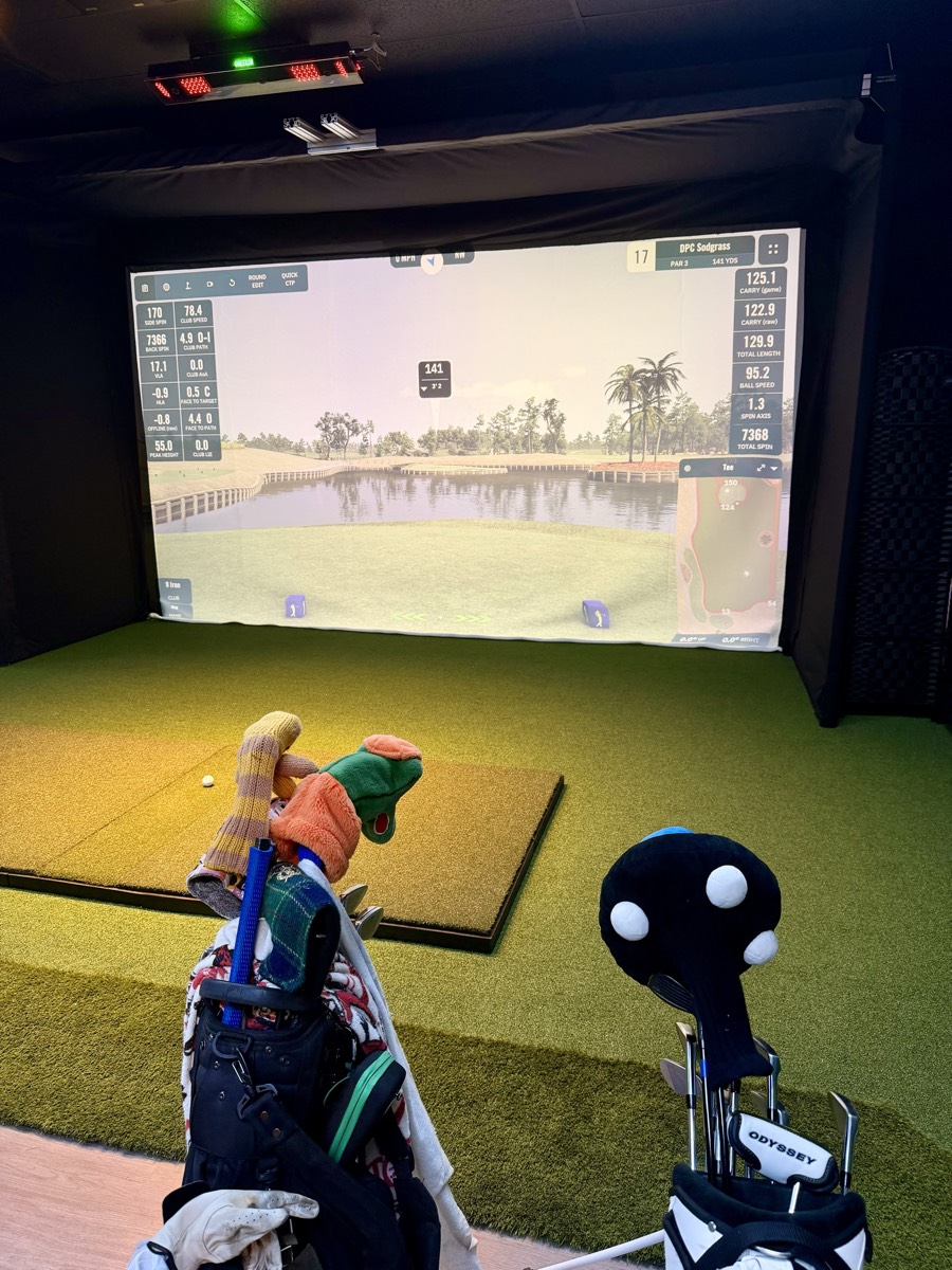Golf simulator bay with premium clubs and equipment